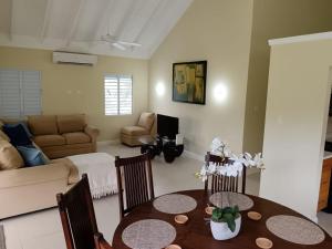 a living room with a table and a couch at Villas Richmond Estate - Ocho Rios in Richmond