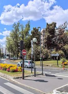 een straat met een verkeerslicht en een auto op de weg bij Rose Blossom apartment in Paris in Vanves