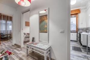 a living room with a table and a mirror at ANGOLO ALLA STAZIONE - Bilocale ristrutturato zona stazione e ospedali in Pavia