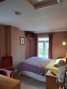 a bedroom with a large bed and a window at The Prince of Wales in Huntingdon