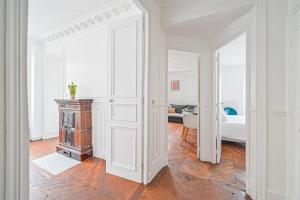 Biały pokój z sypialnią, łóżkiem i kominkiem w obiekcie Le Ruby D'Hauteville - Coeur de Paris - Unique - Spacieux 6 couchages w Paryżu