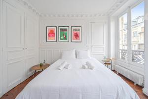 biała sypialnia z dużym białym łóżkiem w obiekcie Le Ruby D'Hauteville - Coeur de Paris - Unique - Spacieux 6 couchages w Paryżu