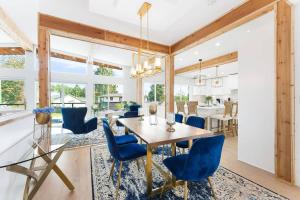 A Custom Luxury House Near Metrotown/YVR/SFU في برنابي: غرفة طعام مع طاولة وكراسي زرقاء