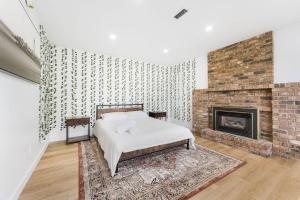 a bedroom with a bed and a fireplace at A Custom Luxury House Near Metrotown/YVR/SFU in Burnaby