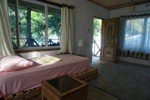 1 dormitorio con cama y ventana grande en Cocoa Village Guesthouse, en Obo