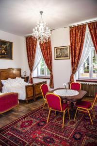 um quarto com uma cama, uma mesa e cadeiras em Łódzki Pałacyk - Pokoje pałacowe em Lódź