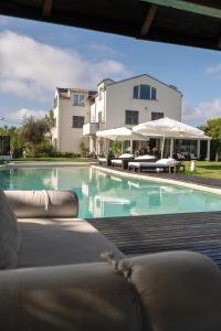 a swimming pool with chairs and umbrellas next to a building at Villa VERNEY in Albisola Superiore
