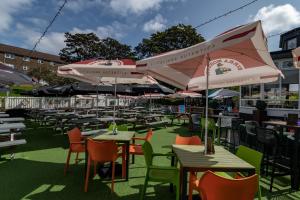 un restaurante al aire libre con mesas, sillas y sombrillas en The Abbey Inn, en Paisley