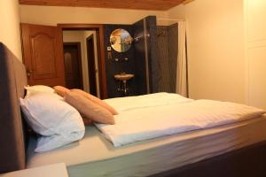 łóżko z białą pościelą i poduszkami w pokoju w obiekcie Landhaus ideal 2 w mieście Wachenheim an der Weinstraße