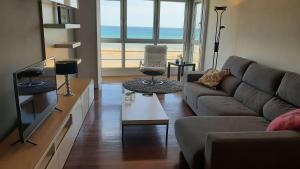 een woonkamer met een bank en een tafel bij Egona - Bañeru 3 Vivienda en 1 línea de playa centro ciudad in Zarautz