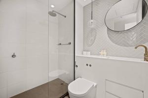 een badkamer met een douche, een toilet en een spiegel bij Level 59 Delightful City Central 3B2B1C Apartment in Melbourne