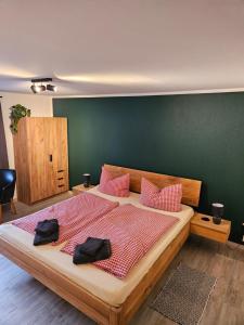a bedroom with a large bed with pink pillows at Cafe-Restaurant Vedder in Herscheid