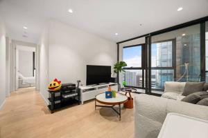 een woonkamer met een bank en een flatscreen-tv bij Level 59 Delightful City Central 3B2B1C Apartment in Melbourne
