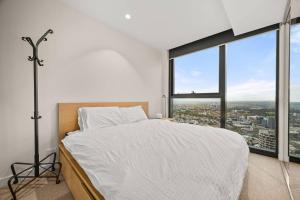 een slaapkamer met een bed en een groot raam bij Level 59 Delightful City Central 3B2B1C Apartment in Melbourne