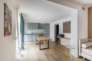 ein Wohnzimmer und eine Küche mit einem Tisch und einem Sofa in der Unterkunft Diana - Sirio- Aura Montegrotto Terme Lovely Apartments! in Montegrotto Terme