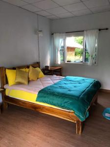 a large bed in a room with a window at บ้านสวนม่วนใจโฮมสเตย์ 
