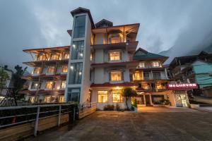 a large building with many windows on a street at Meghavan Resort By DLS Hotels in Dharamshala