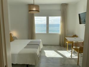 a bedroom with a bed and a view of the ocean at La Sirena del Viento in Los Caños de Meca