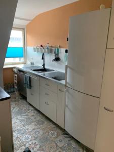 a kitchen with a white refrigerator and a sink at Hofesh in Altdorf