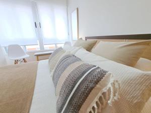 1 cama grande con sábanas blancas y almohadas. en Apartamento céntrico en Vigo, en Vigo