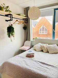 een slaapkamer met een bed en een raam bij Canal House - Homestay in Alkmaar