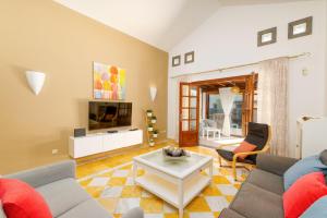 ein Wohnzimmer mit einem Sofa und einem TV in der Unterkunft Villa Alhambra by Villa Plus in Playa Blanca