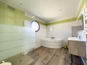 a bathroom with a tub and a sink at 3102-Villa 6 couchages avec piscine in Elne +8 photos