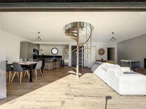 a living room with a white couch and a spiral staircase at 3102-Villa 6 couchages avec piscine in Elne