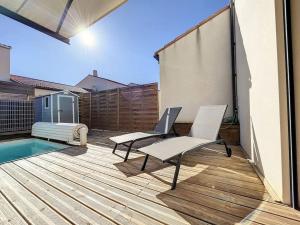a patio with two chairs and a pool at 3102-Villa 6 couchages avec piscine in Elne