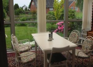 a table and chairs in a room with a large window at Holiday Home Kirkeby Feriehus in Roslev