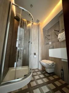 La salle de bains est pourvue d'une douche et de toilettes. dans l'établissement NACRE RESIDENCE, à Istanbul