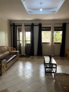 sala de estar con sofá y mesa en Inviting 3-Bed House in Akright City Jennifers, en Buzzi