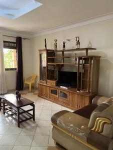 una sala de estar con un gran centro de entretenimiento de madera en Inviting 3-Bed House in Akright City Jennifers, en Buzzi