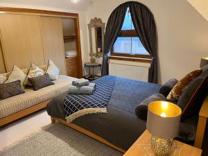 een slaapkamer met een bed, een bank en een raam bij Luxury Seaside Home with Incredible Views in Fife