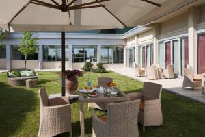 patio con tavolo, sedie e ombrellone di Hotel Miro' a Calenzano