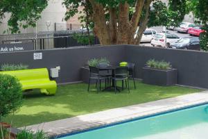 a yard with a table and chairs next to a pool at 1 bedroom unit fully furnished with back up generator in Johannesburg