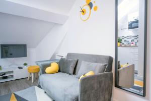 a living room with a gray couch and yellow pillows at ★Le Petit Cosy Vincennes★ in Vincennes