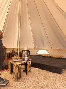 Zelt mit einem Bett und einem Tisch davor in der Unterkunft Domaine d'Escapa in Estipouy