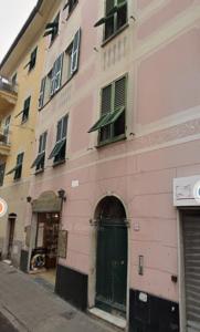 a pink building with a green door on a street at Civico69 in Rapallo