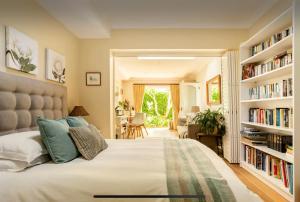 a bedroom with a large bed with book shelves at Guest suite - Leafy Constantia Guest House in Cape Town
