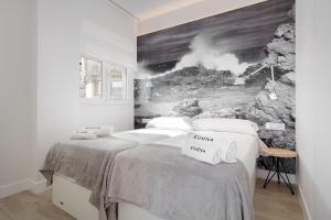 サラウツにあるApartamentos Egona Zarautz sobre el marのベッドルーム1室(壁に絵画が描かれたベッド1台付)