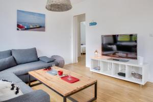 uma sala de estar com um sofá e uma televisão em Escapade Bretonne pour 4 a Fouesnant em Fouesnant