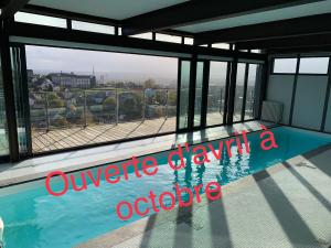 - une vue sur la piscine dans un bâtiment dans l'établissement Rouen ECO LODGES maison entière avec terrasse dans jardin potager piscine parking, à Rouen