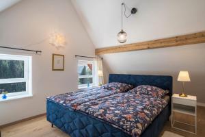 a bedroom with a blue bed and a window at Haus Wiesenruhe in Seebach