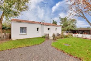 a white house with a fence and a yard at Calme et serenite pour une escape a 6 in Commequiers