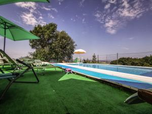 una piscina con sedie e ombrellone accanto ad essa di Casa vacanze Guardea a Guardea