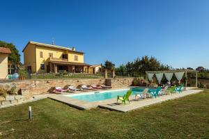 ein Swimmingpool mit Stühlen und ein Haus in der Unterkunft Villa Poggio al Sole by VacaVilla in Foiano della Chiana