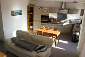 格勒諾布爾的住宿－3 min sortie A480: wifi fibre - lit bébé - balcon，客厅配有沙发和餐桌,厨房配有桌子