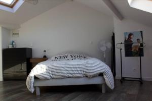 een slaapkamer met een bed met een bord uit New York erop bij 3 min sortie A480: wifi fibre - lit bébé - balcon in Grenoble