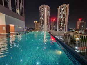 una piscina en la parte superior de un edificio por la noche en Chambers Residences Suites KLCC, en Kuala Lumpur